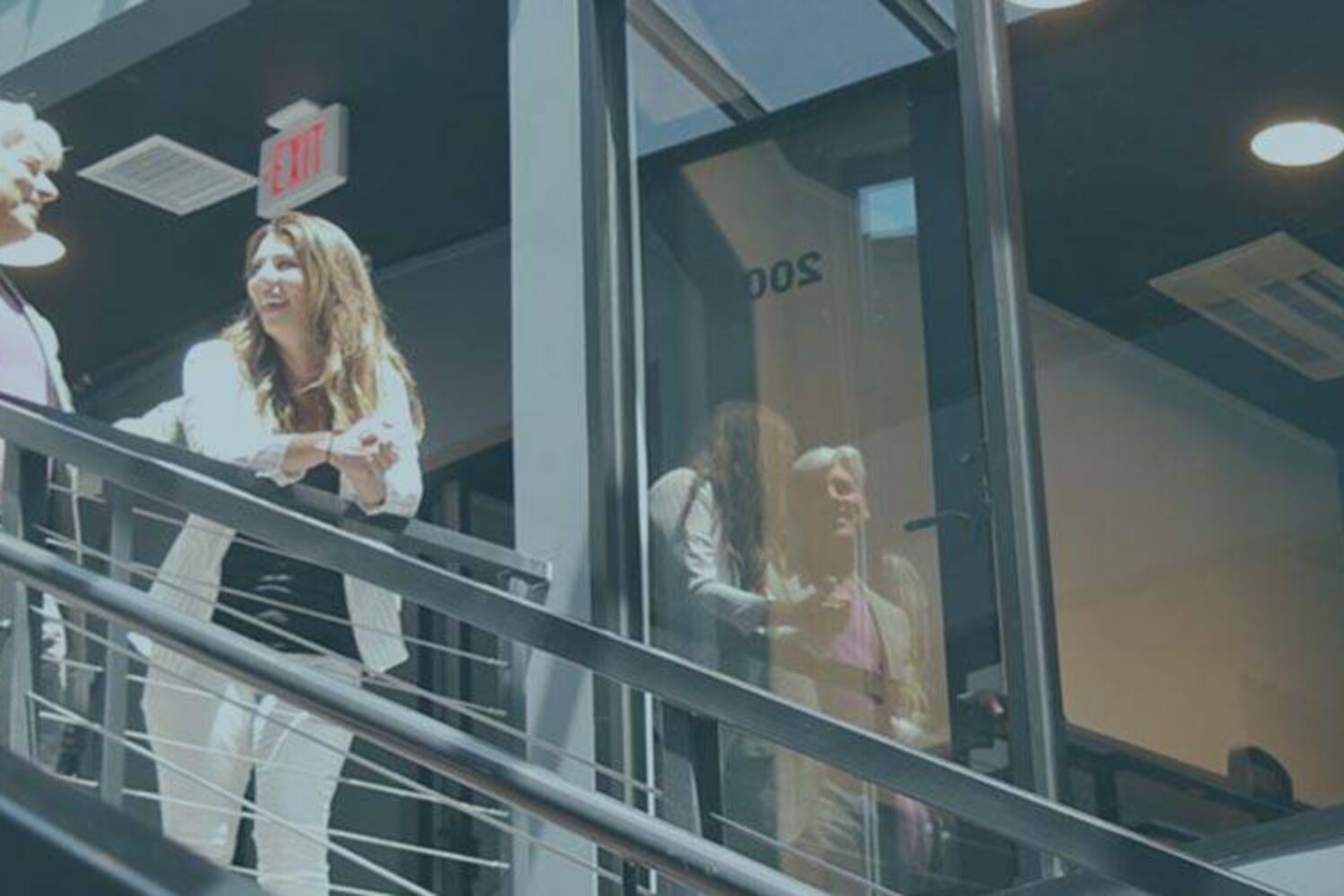 Jim Ellis and Lauren Fehlhaber stand on the stairway of The Film Hub