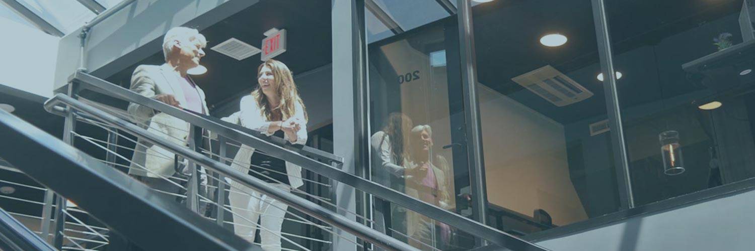 Jim Ellis and Lauren Fehlhaber stand on the stairway of The Film Hub