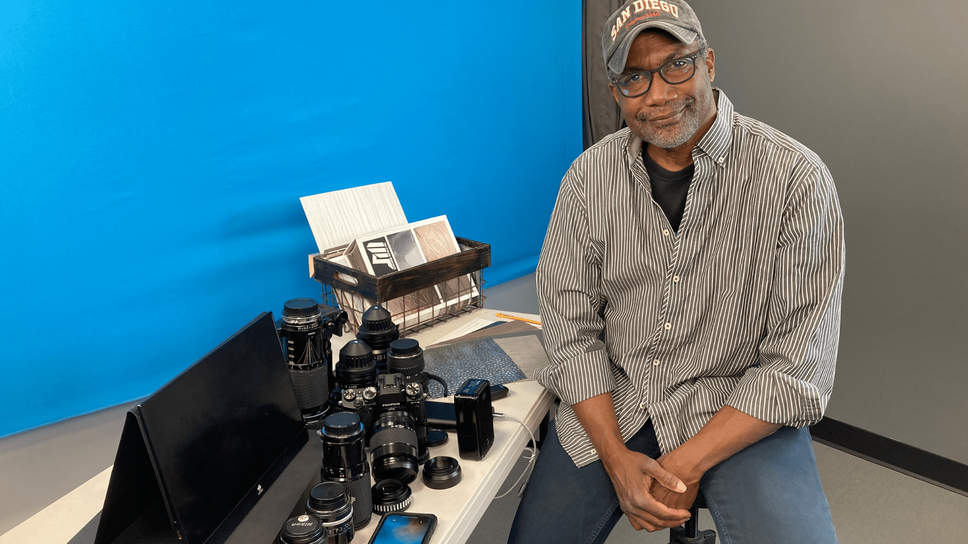 Elias Acosta and his collection of camera lenses on a table