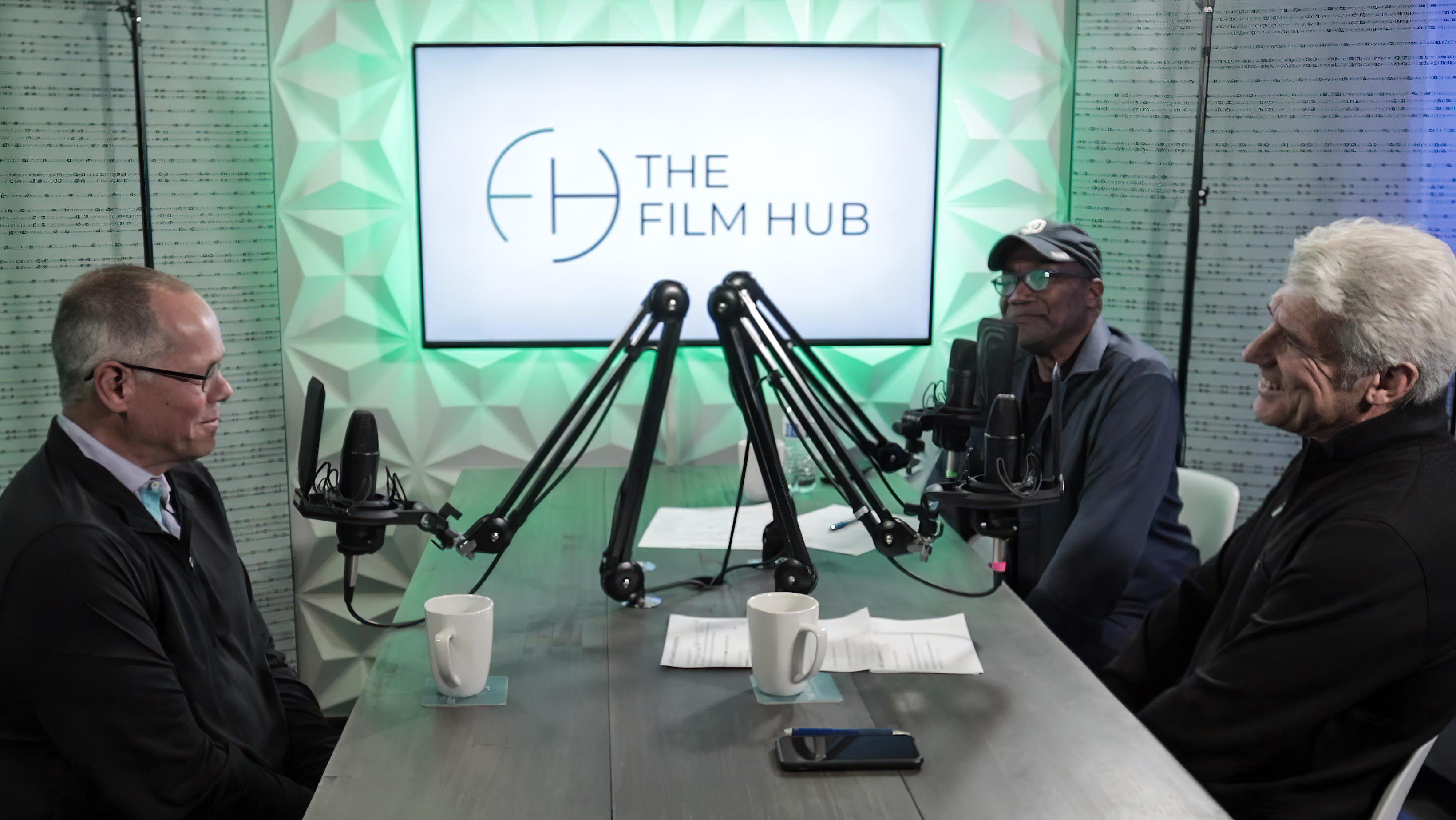 Jeff Deverett sits across Jim Ellis and Elias Acosta at The Film Hub podcast studio
