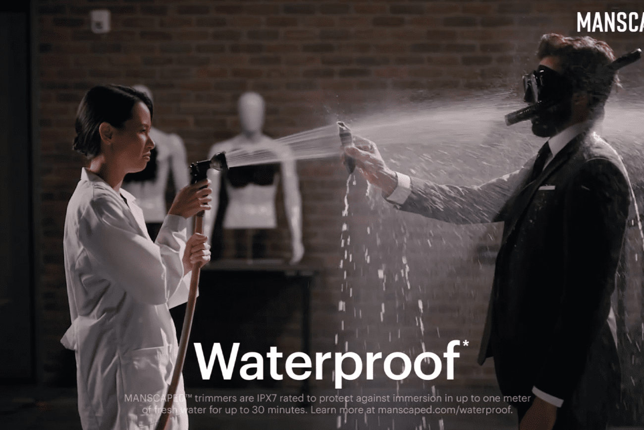 woman sprays man with a water hose during a commercial shoot