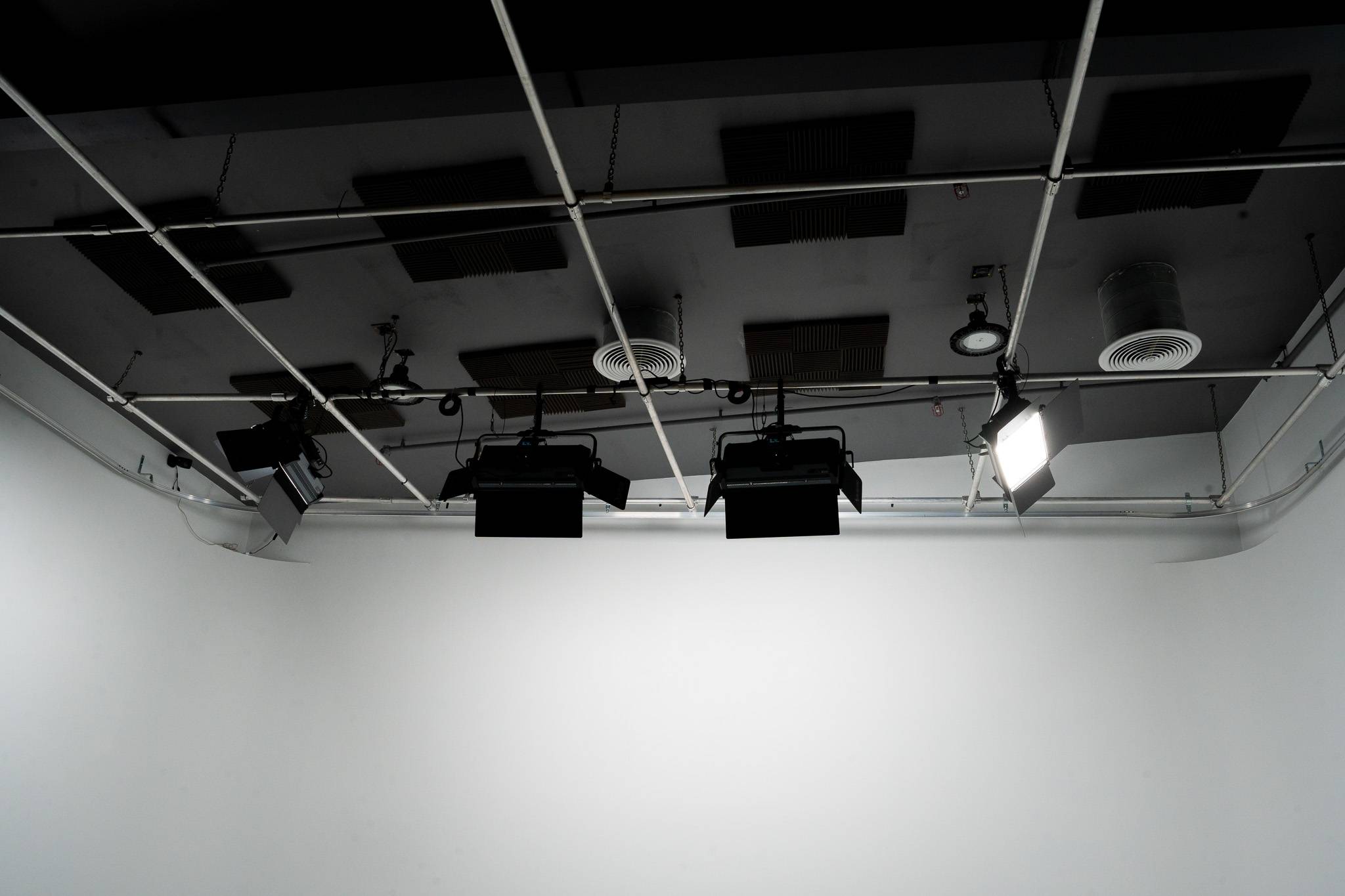 Ceiling-mounted Aputure Nova P600c RGB LED light panels installed on a lighting grid above the white cyclorama in Stage 2 at The Film Hub.